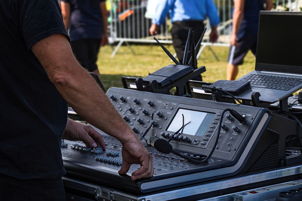 Technicien réglant une console de mixage pendant un événement en plein air
