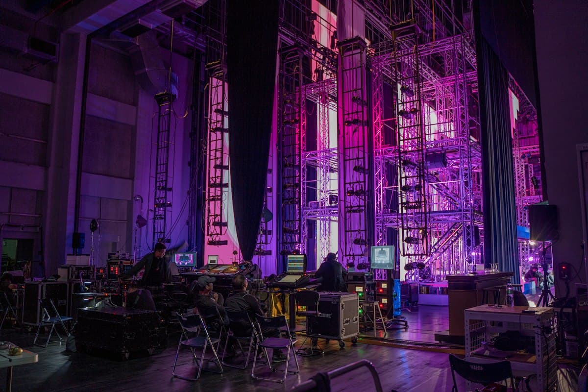 Équipe technique au travail dans les coulisses d’une scène éclairée en violet